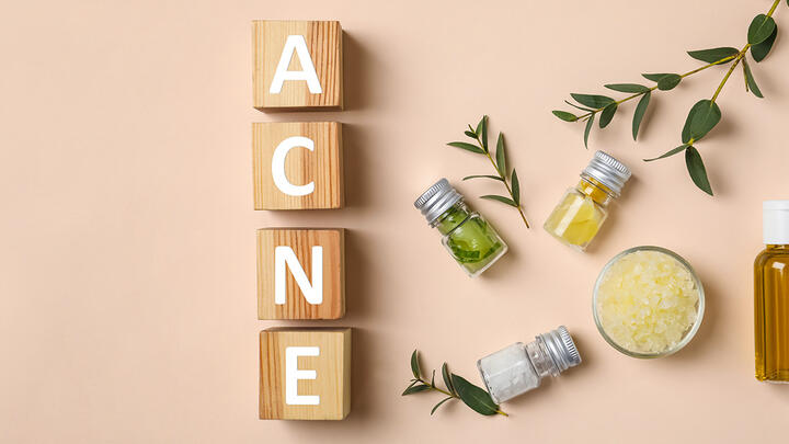 Vertical wooden blocks speling ACNE and various plants and natural remedies the right side of the image